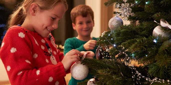 two-kids-decorating-holiday-tree_iStock